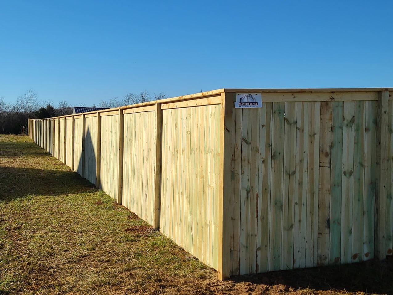 Full privacy wood fence with cap and trim design installed around a yard in Middle Tennessee