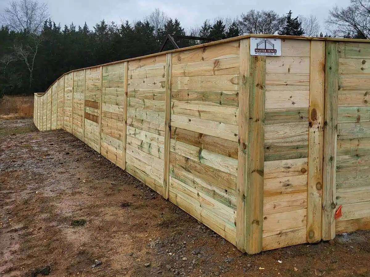 Horizontal privacy wood fence with cap top design installed around a property